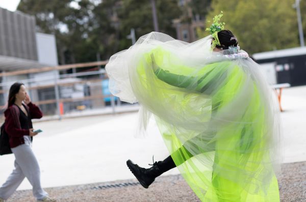 A woman in green chiffon dress kicks her heals up