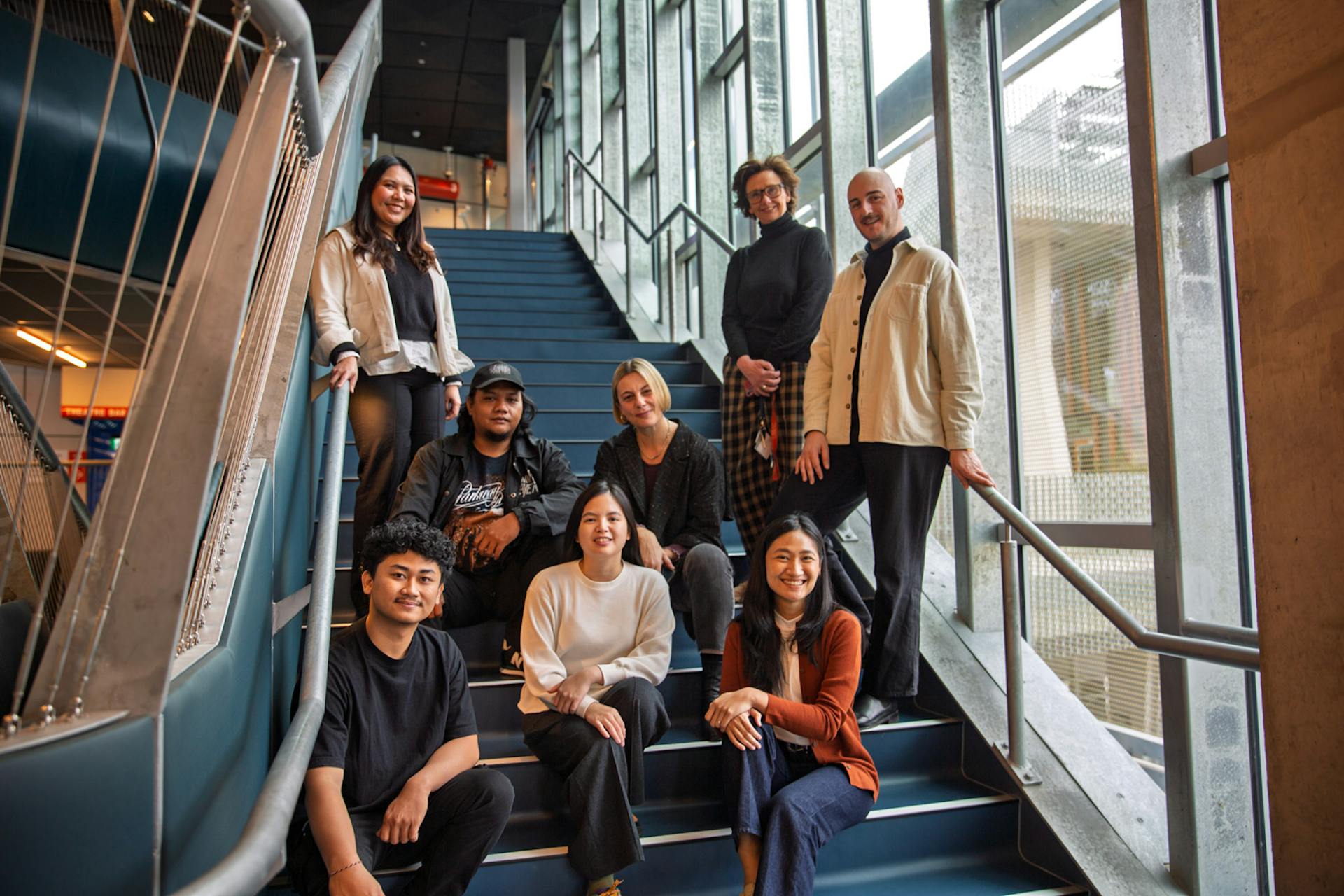 A group of people sit or stand on a staircase