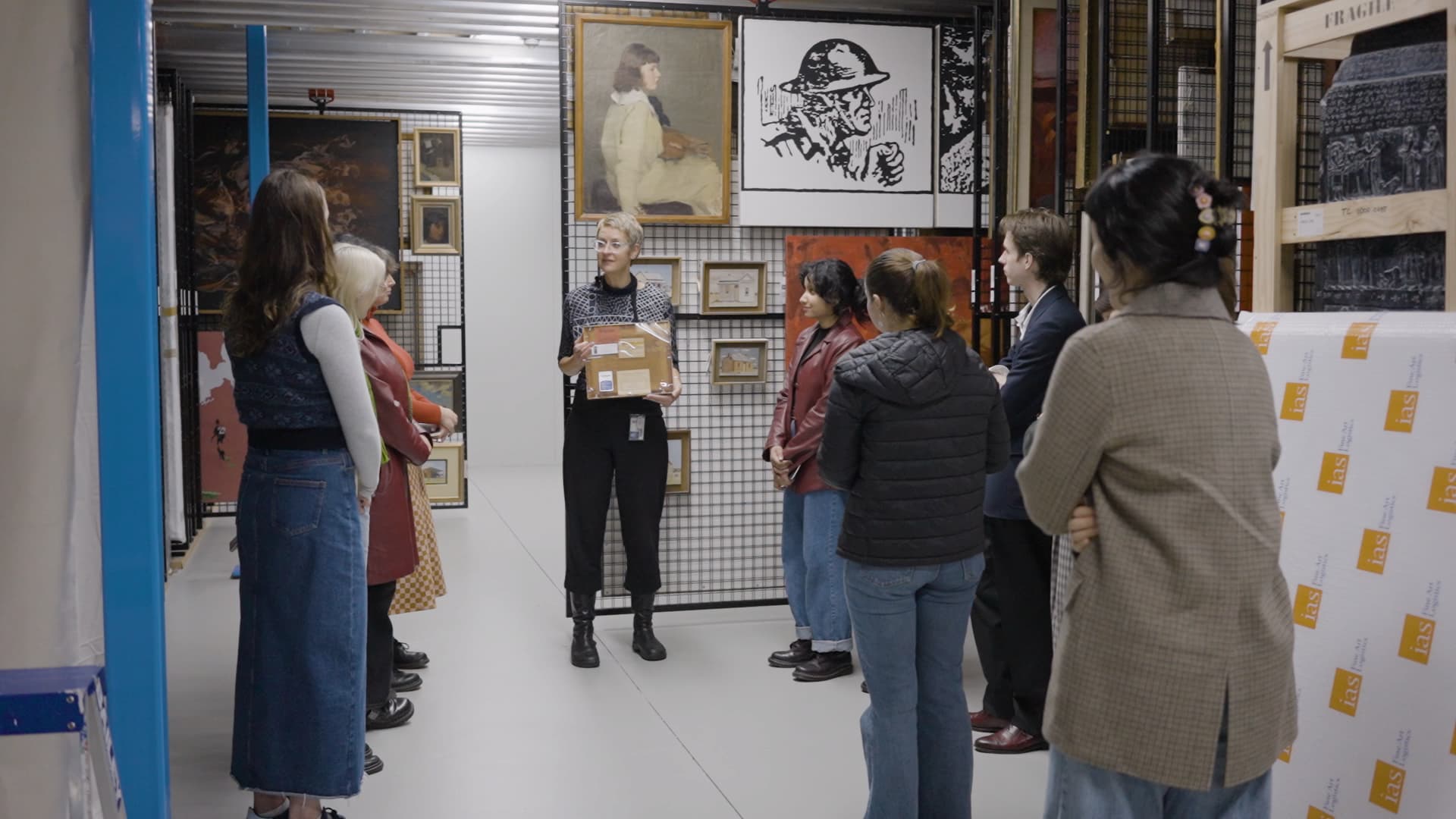 Students listen to curator talking about art in a collection store