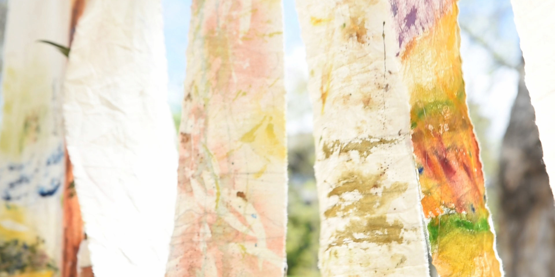 Coloured cloth hang from a line blowing in the wind