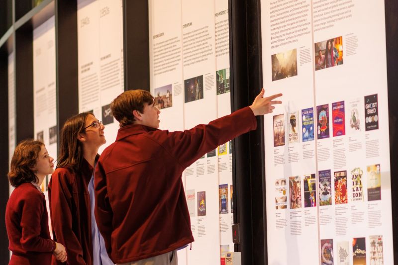 Students point at information on a wall