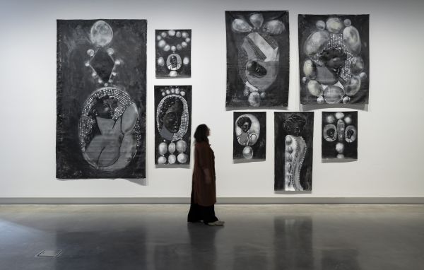 a person walks infront of a large black and white artwork