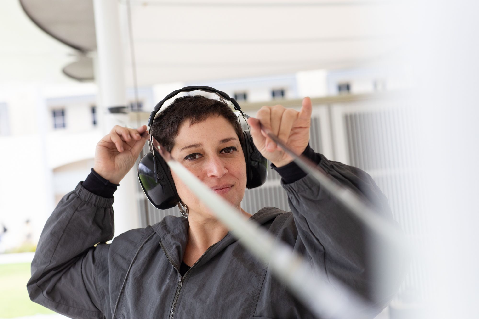 A woman holds wires attached to headphones